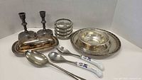 Overview shot of all items including candlesticks, butter dish, coasters, nested bowls, serving spoons