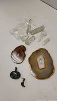 Display of clear quartz crystal points, polished agate slices, green stone pendant and earrings.