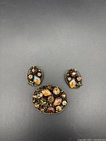 Photo of the vintage brooch and clip-on earrings together, showing overall design and color