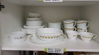 Corelle dinnerware pieces grouped showing plates, vegetable dishes, creamer, sugar bowl, and small bowls.