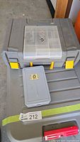 Closed steel box with yellow latches and a smaller plastic container on top