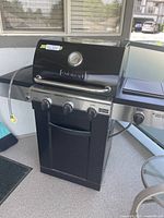 Front view of closed grill showing hood, handle and overall structure