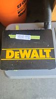 Closed black plastic Dewalt carrying case with yellow Dewalt logo on top.