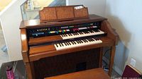 Photo of vintage Lowrey D-325 electric organ showcasing dual keyboard and control buttons panel