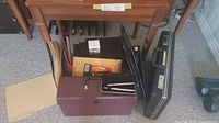Overview of the lot showing briefcase, black binders, pens, file folders