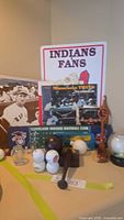 Photo showing a display of Cleveland Indians and Minnesota Twins baseball memorabilia including baseballs, football, golf balls, and collectible items.