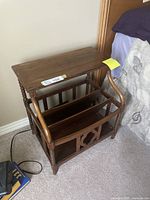 Front angle showing wooden side table with magazine rack; turned legs and built-in compartments visible