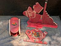 Three early 1930s folk art hand painted wooden pieces: ice skate, small chair, and teapot shape.