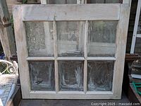 Front view of early pine window showing six intact glass panes and distressed wood frame.