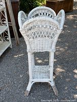 Front and side view of white painted wicker plant holder with decorative diagonal and lattice woven patterns.