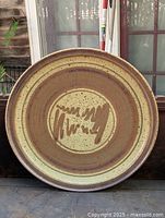 Top view of the pottery charger showing concentric rings and speckled pattern.