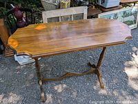 Full view of wooden hall or sofa table showing smooth refinished maple top with subtle wood grain, curved edges and turned legs with cross brace.