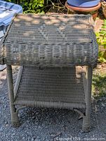 Top-front angled view of green painted wicker side table showing woven pattern and condition.