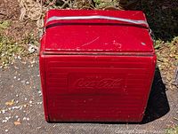 Full view of red vintage Coca-Cola portable cooler showing size, color, and handle.