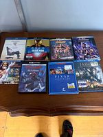 First group of eight Blu-ray and DVD movie cases on wooden table