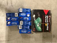 Electric Putting Partner box next to eight Srixon Hi-Spin golf ball sleeves