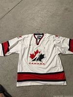 Front of white Nike Team Canada hockey jersey showing crest, colour pattern and overall condition