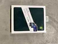 Front of retail package showing dark green neoprene tablet case