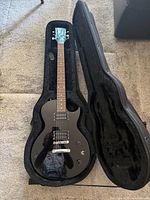 Guitar in open plush-lined SKB case showing body, neck, pickups, knobs and hardware