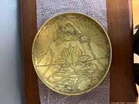 Front of metal plate showing etched lotus and water motif