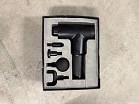 Massage gun with three attachments in original foam packaging