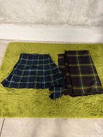 Kilt folded showing pleats beside folded plaid blanket