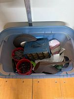 Top view of open tote showing nails, discs, organizer, watering jug, dustpan