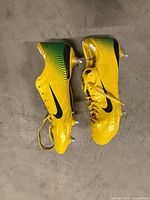 Side view of both cleats showing colour, swoosh logo, overall wear