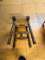 Stool upside down showing wooden frame and rush seat underside