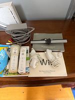 All items laid out: console, controllers, manuals, cables, sensor bar, game