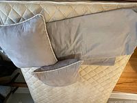 Photo of medium beige ultra-suede queen size duvet cover and two matching pillow covers laid on mattress.