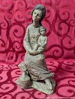 Full view of figurine front on red patterned backdrop