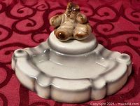 Full view ashtray front, gloves on pedestal