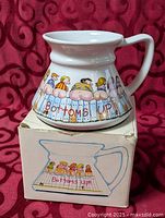 Mug on top of box showing cartoon graphics and caption