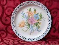 Full view of ceramic plate showing floral center and blue reticulated rim