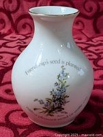 Front view of ceramic vase with quote and flower graphic