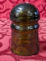 Front view of olive-amber glass insulator showing overall shape