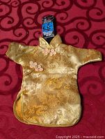 Front view of gold brocade doll cheongsam