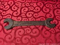 Full view of steel double open-end wrench on patterned cloth background