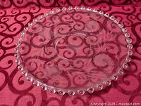 Top view of clear glass platter showing hobnail rim and etched design