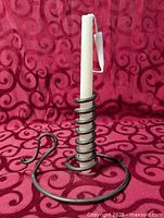 full view of iron spiral candle holder with candle