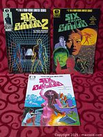 Front covers of issues #1, #2, #3 displayed on red fabric