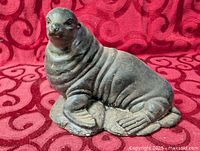 Front three-quarter view of cast sea lion figurine on textured base