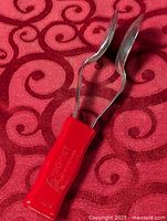 Full view showing spoons, metal stem and red handle