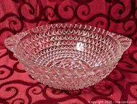 Oblique view of clear pressed glass bowl showing overall form and handles