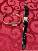 Two Nine West wrist watches displayed on fabric