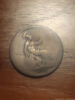 Reverse side of the 1874 coin showing seated Britannia holding trident and shield, with date 1874 below and worn surface.