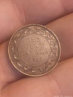 Reverse side of 1911 Canadian one cent coin showing text and decorative wreath.