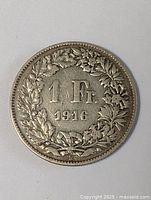 Obverse side of Swiss 1 Franc coin displaying denomination and year (1916) surrounded by a detailed wreath.