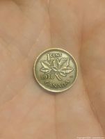 Reverse side of the 1938 Canadian penny showing two maple leaves, denomination, year and country name.